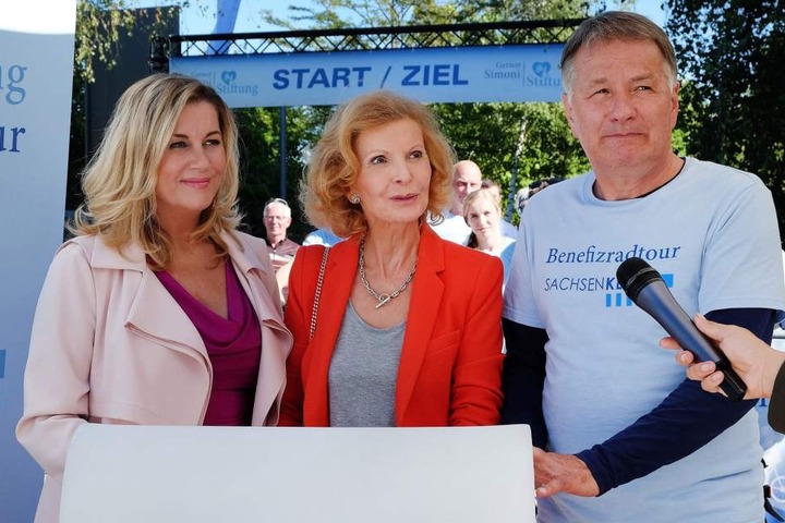 Sarah Marquardt (Alexa Maria Surholt, l.), Ingrid Rischke (Jutta Kammann, M.) und Dr. Roland Heilmann (Thomas Rühmann, r.) geben den interessierten Journalisten Auskunft über die Benefiz-Radtour zu Gunsten der Gernot-Simoni-Stiftung.