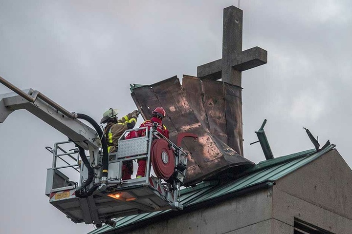 Von einem Hubsteiger aus versuchen Feuerwehrmänner, das Blechdach eines Kirchturms im Stadtteil Gallus zu sichern, welches sich losgerissen hatte.