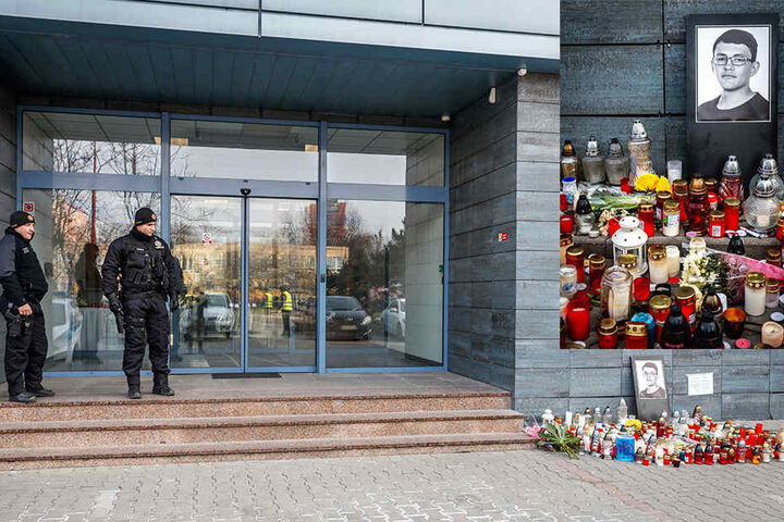 Vor dem Eingang zum Bürogebäude des Nachrichtenportals «aktuality.sk» haben Menschen Kerzen und Blumen im Gedenken an die beiden Ermordeten niedergelt. Das Gebäude wird von Polizisten bewacht.