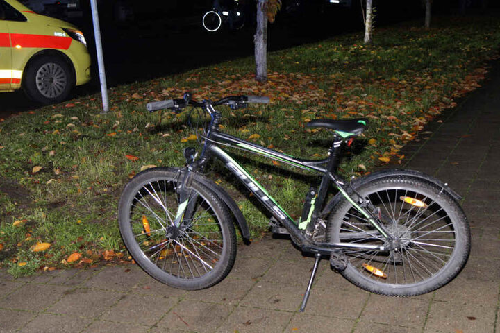 Das Fahrrad des Jungen steht auf einem Gehweg.