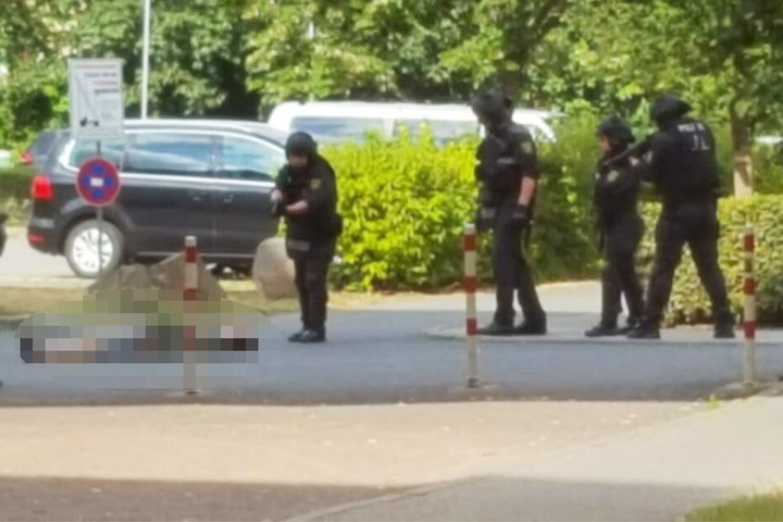 Ein Polizist beugt sich über eine am Boden liegende Person.
