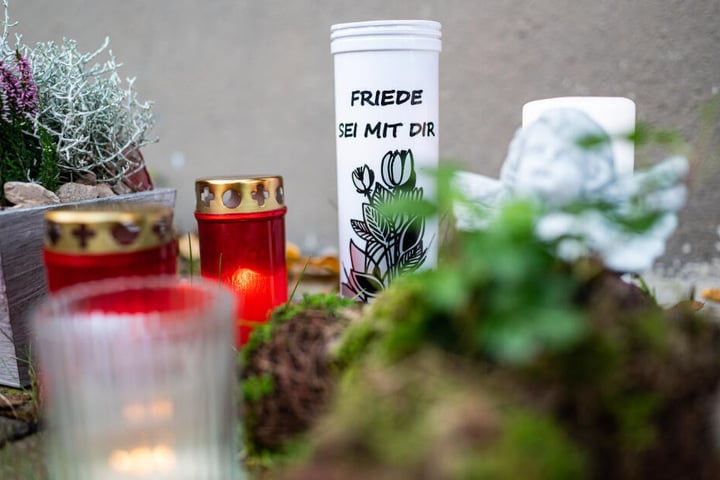 Vor dem Haus, wo der Dreijährige getötet wurde, legten Menschen Blumen und Kerzen hin.