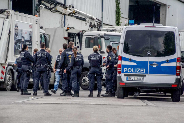 Polizisten auf dem Gelände einer Müllentsorgungsfirma.