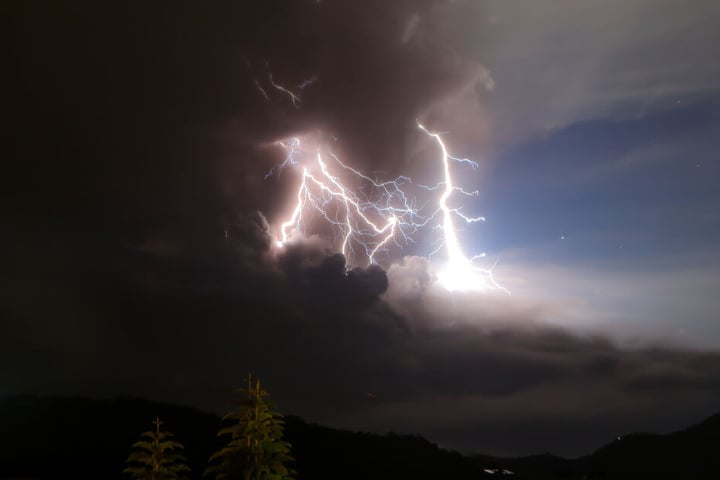 Ein Blitz schlägt während des Vulklanausbruches in eine Rauchwolke ein.