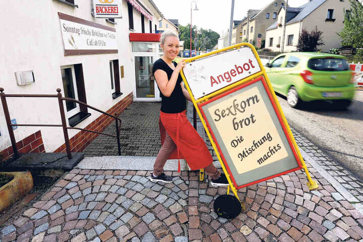 Sexkornbrot im Angebot! Franziska Müller schiebt einen Werbe-Aufsteller vor
die Tür der Bäckerei.