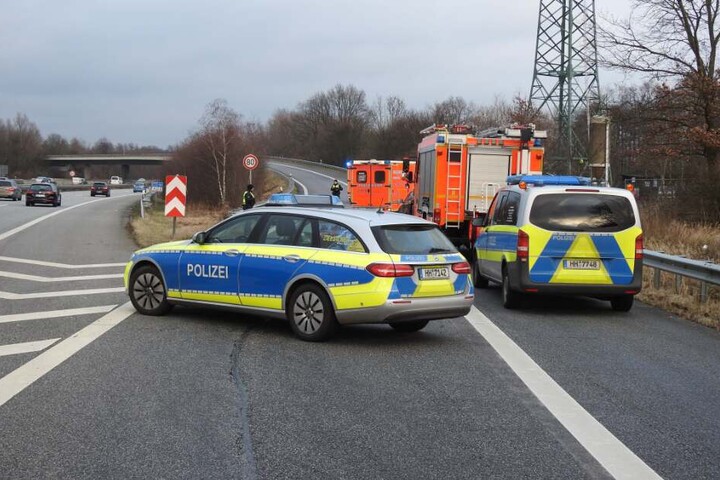Einsatzkräfte stehen an der Unfallstelle auf der A1.