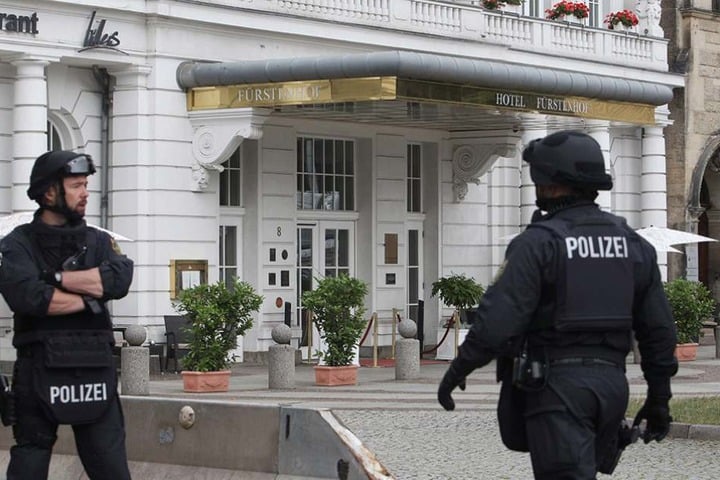 Zwei Polizisten stehen in voller Ausrüstung vor dem Hotel "Fürstenhof" in Leipzig.