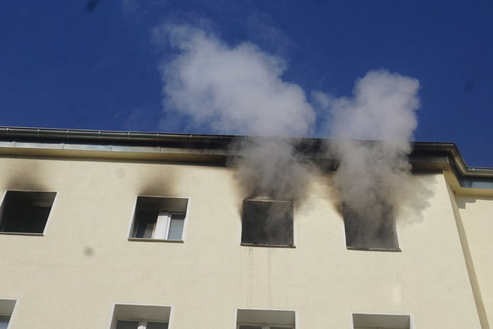 Aus einer Wohnung im Dachgeschoss tritt dichter Rauch aus.
