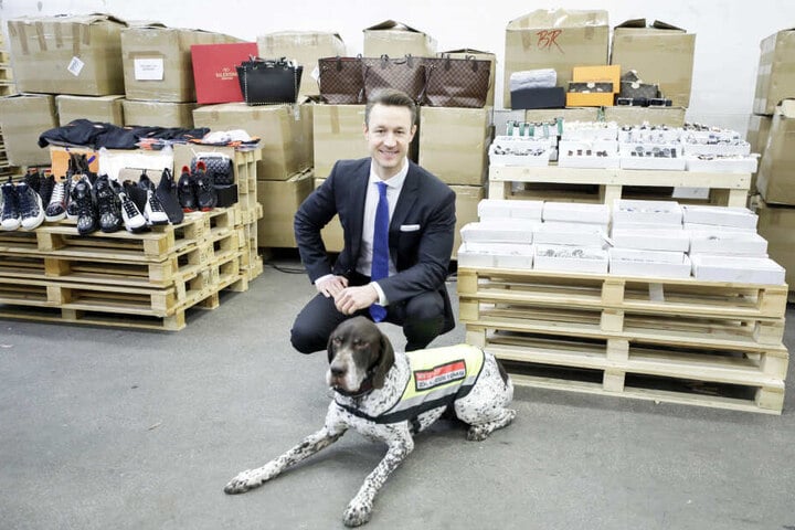 Finanzminister Gernot Blümel (38) präsentiert mit einem Zollhund einige der rund 2400 gefälschten Produkte.