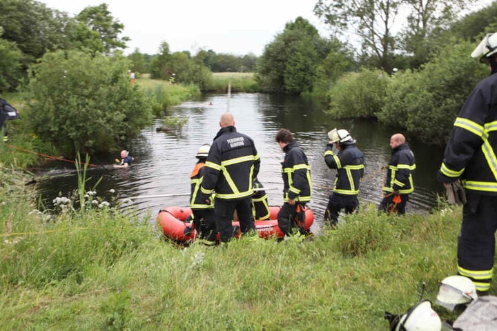 Feuerwehrleute suchen nach dem Jungen im Wasser.