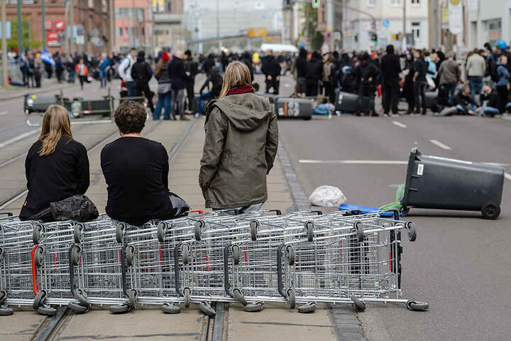 Teilnehmer einer Demonstration gegen einen geplanten Aufmarsch der rechten Szene haben am Straßenbarrikaden mit Mülltonnen und Einkaufswagen errichtet.