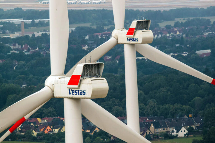 Zwei Windräder drehen sich vor einer Ortschaft. (Archivbild)