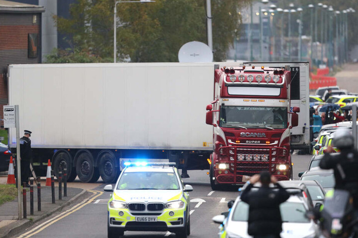 Ein Polizeiauto eskortiert den LKW, in dem 39 Leichen gefunden worden waren, beim Verlassen des Waterglade Industrieparks.