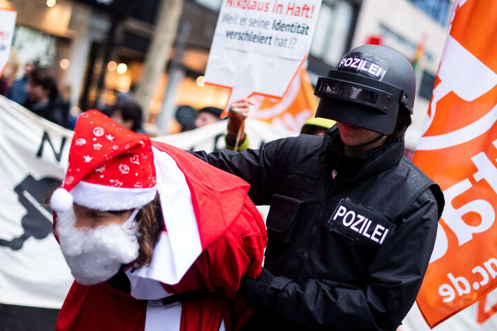 Ein als Polizist verkleideter Teilnehmer der Demo verhaftete den Weihnachtsmann.