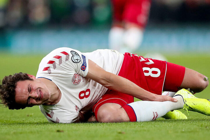 Thomas Delaney mit schmerzverzerrtem Gesicht. Er hält sich den rechten Knöchel.