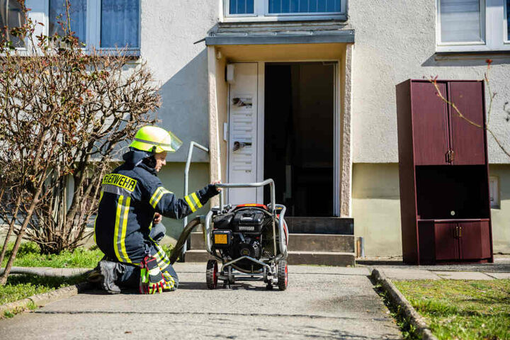 Ein Feuerwehrmann entlüftet die Wohnung mit der Hilfe eines Druckbelüfters.