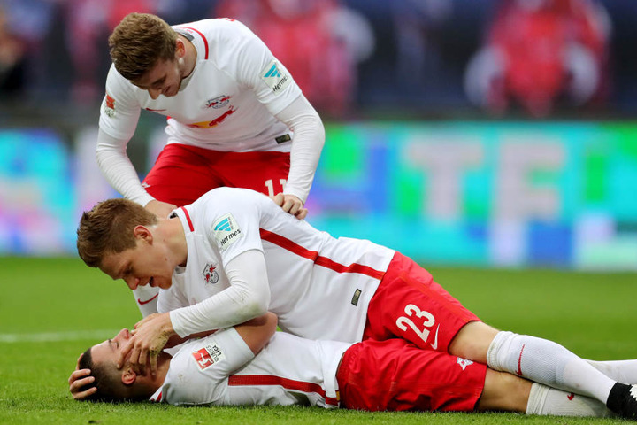 Leipzigs Marcel Halstenberg (m.) und Timo Werner (hinten) kümmern sich nach dem 4:0 um den verletzten Torschützen Diego Demme.