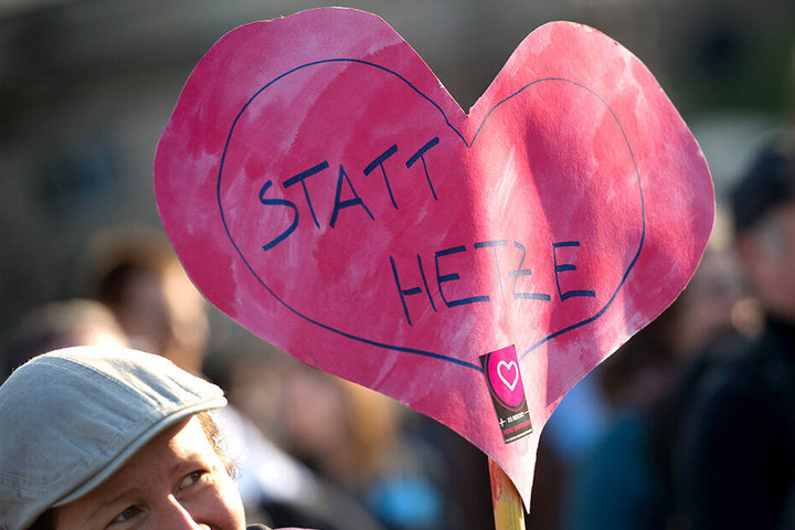 "Herz statt Hetze" steht auf einem selbstgebastelten Herz-Banner.