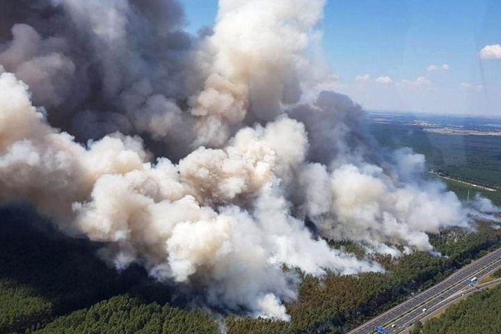 Ein Polizeihubschrauber zeigt die Ausmaße des Großbrandes neben der A9 bei Fichtenwalde.