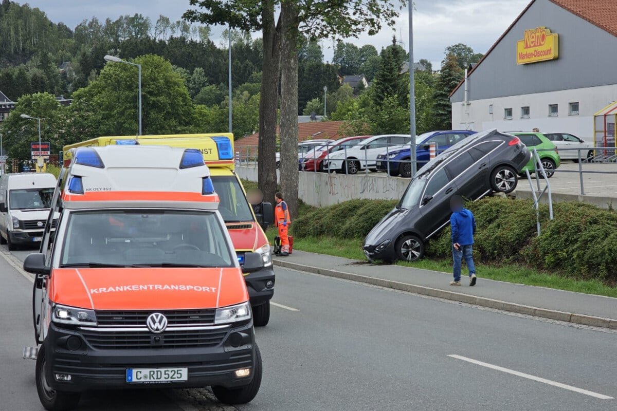 Erzgebirge: Mercedes kracht durch Geländer und fliegt vom Netto-Parkplatz