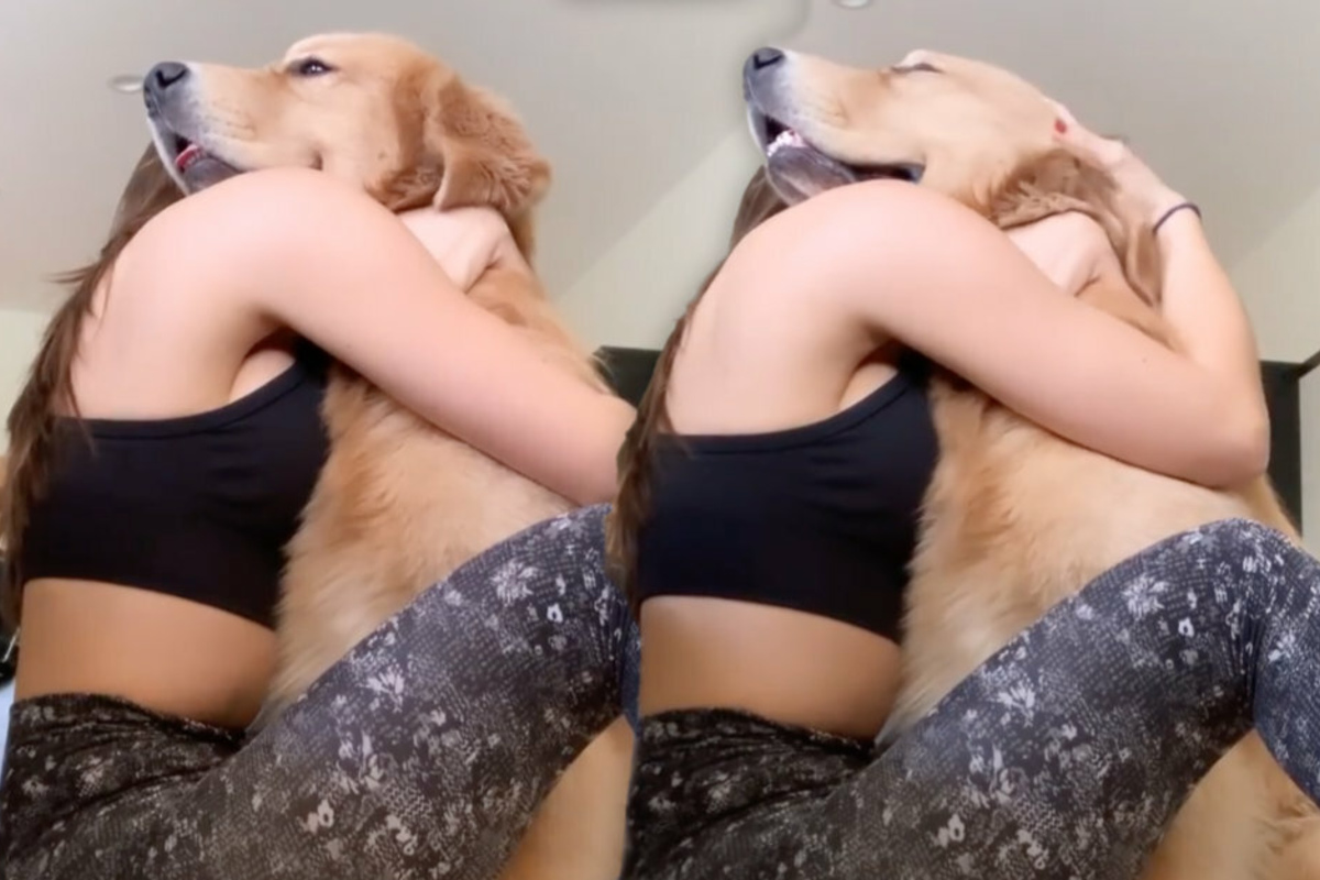 Attractive lady hugs her dog: he can’t get enough!