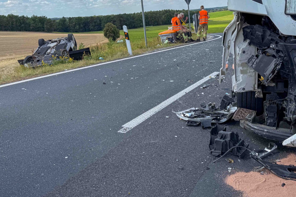 Heftiger-Abbiegeunfall-Auto-nach-Kollision-mit-Lkw-kopf-ber-auf-Feld-gelandet