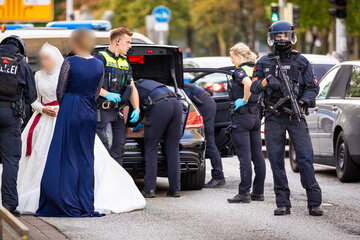 Schwer bewaffnete Polizisten durchsuchen Hochzeitskorso