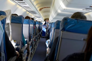 Kopfnuss in der Business Class: Betrunkener Passagier geht auf Flugbegleiter los!
