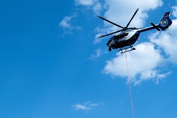 Waldbrand beschäftigt Einsatzkräfte den ganzen Abend: Polizeihubschrauber mit Löschsack vor Ort