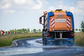 Winterdienst im Sommer: Fahrzeug kühlt Straße mit Wasser, damit es keine Hitzeschäden gibt