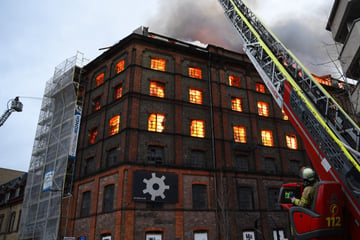 Großbrand in Gewerbegebäude: Brennende Teile stürzen auf Einsatzkräfte!