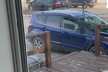 Mann reibt sich die Augen, als er sieht, wer plötzlich in seinem Auto sitzt