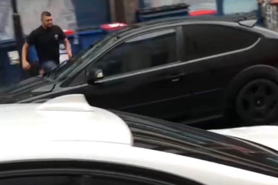 Der unbekannte Mann läuft auf das Auto zu und versucht die Fahrertür zu öffnen. Das gelingt ihm nicht.