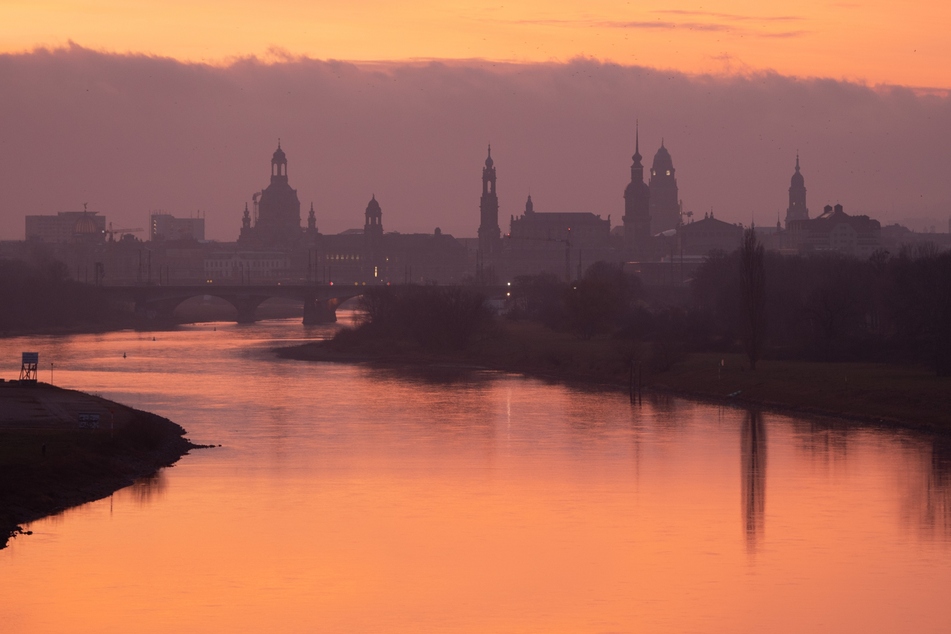 Die Kulisse der Dresdner Altstadt mit der Frauenkirche (l-r), dem Ständehaus, der Katholischen Hofkirche, dem Hausmannsturm, dem Rathausturm und der Kreuzkirche bei Sonnenaufgang.