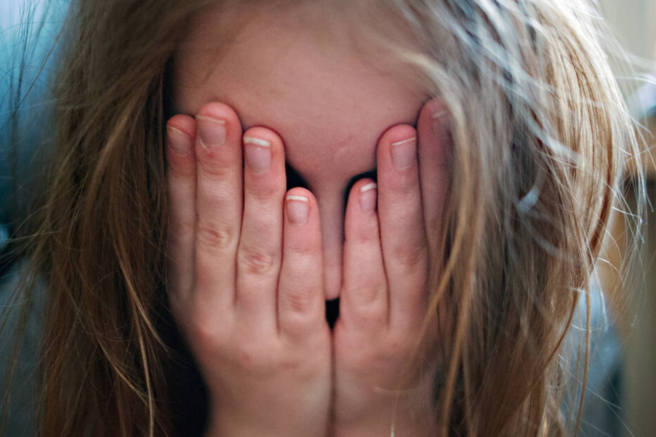 Ein junges Mädchen hält sich die Hände vor ihr Gesicht. (Symbolbild)