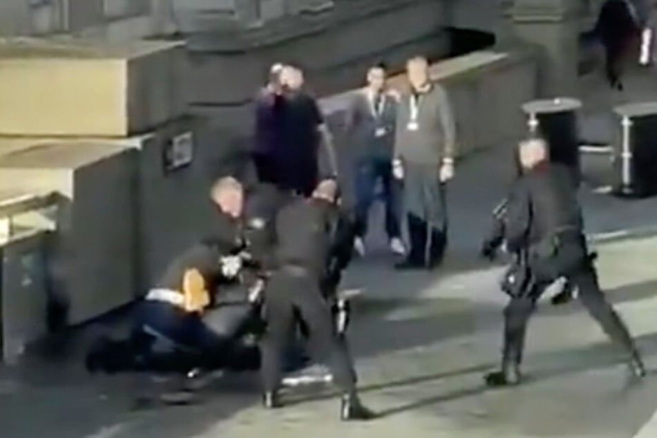Auf der London Bridge umstellen bewaffnete Polizisten den auf dem Boden liegenden mutmaßlichen Attentäter.