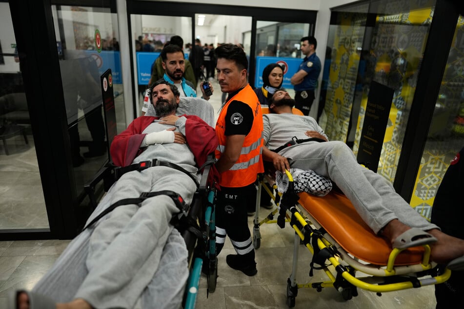 Aktivisten der Global Sumud Flotilla liegen bei ihrer Ankunft auf dem Istanbuler Flughafen auf Tragen.