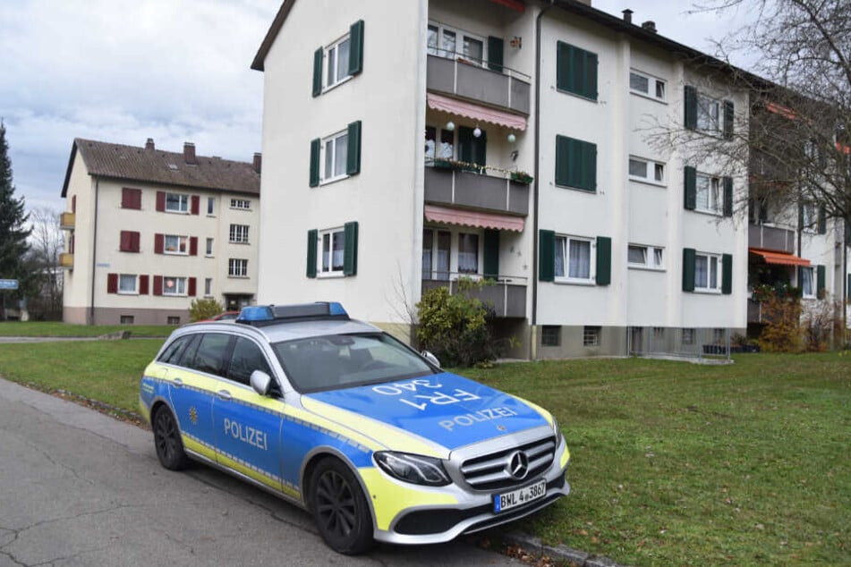 Ein Polizeiauto steht am Sonntag vor den Mehrfamilienhäusern.