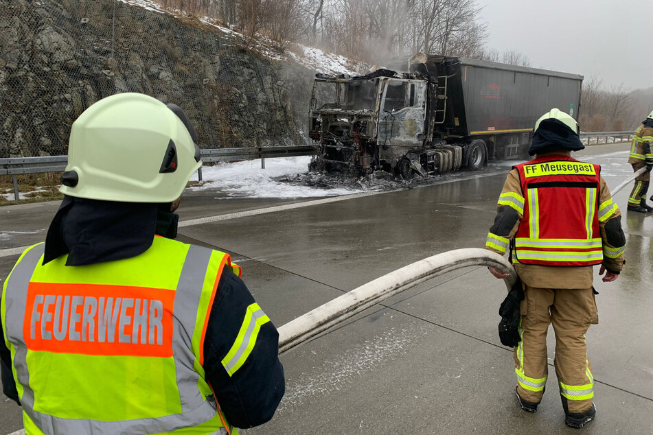 Kameraden der Feuerwehr begutachten den ausgebrannten Lastwagen.