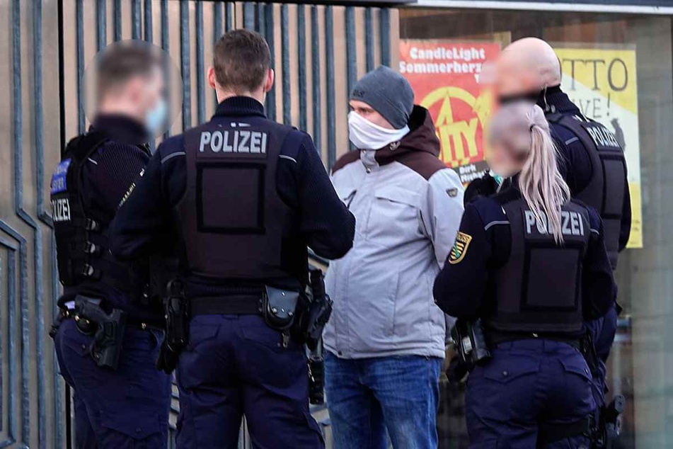 Robert Andres (33, Pro Chemnitz, M.) am 16. Dezember 2020 im Gespräch mit Polizisten vor der Stadthalle Chemnitz.