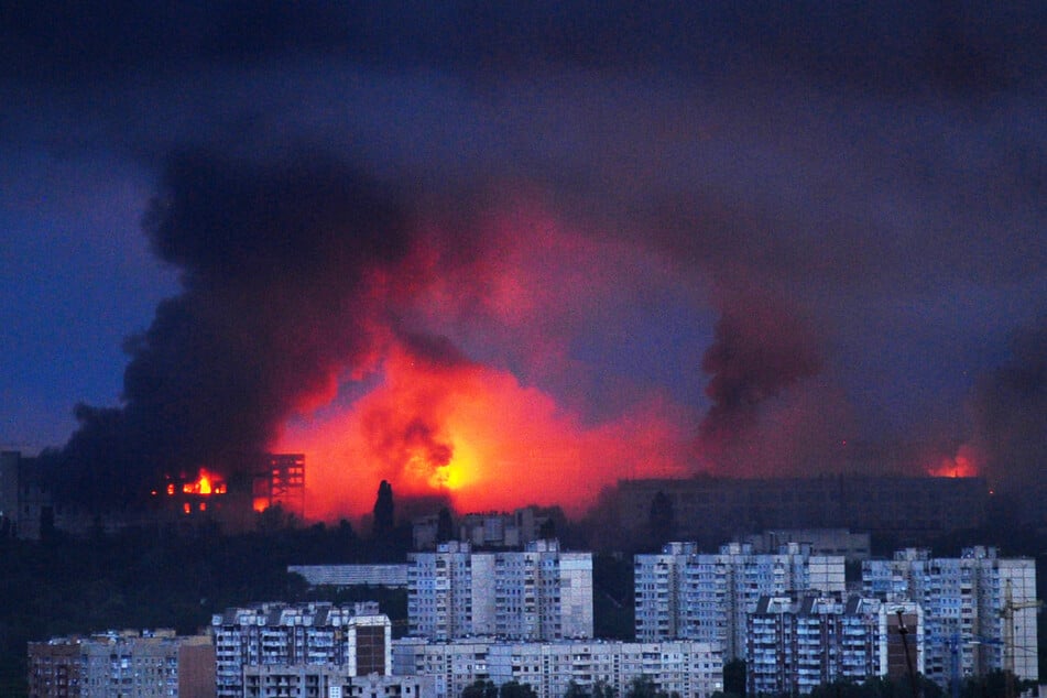 Feuer und Rauch steigen von der Stelle auf, an der eine russische Rakete ein Wohngebiet in Charkiw getroffen hat.