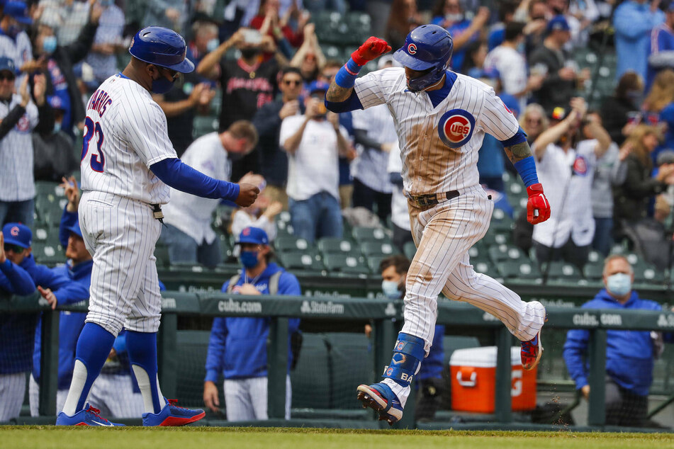 Chicago Cubs' Javier Baez (r.) celebrates his solo home run with third base coach Willie Harris in the second inning against the Milwaukee Brewers.
