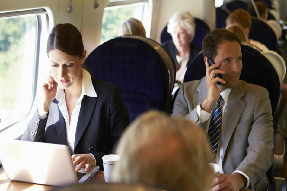Geschäftsleute reisen in einem Zug. (Symbolbild)