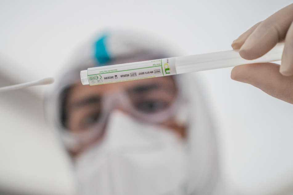 Ein Mitglied des medizinischen Personals in einem Corona-Testzentrum steckt ein Wattestäbchen nach einem PCR-Abstrich zum Test auf Covid-19 in ein Röhrchen. In Berlin ist die Zahl der Todesfälle am Dienstag auf 1066 angestiegen. (Symbolfoto)