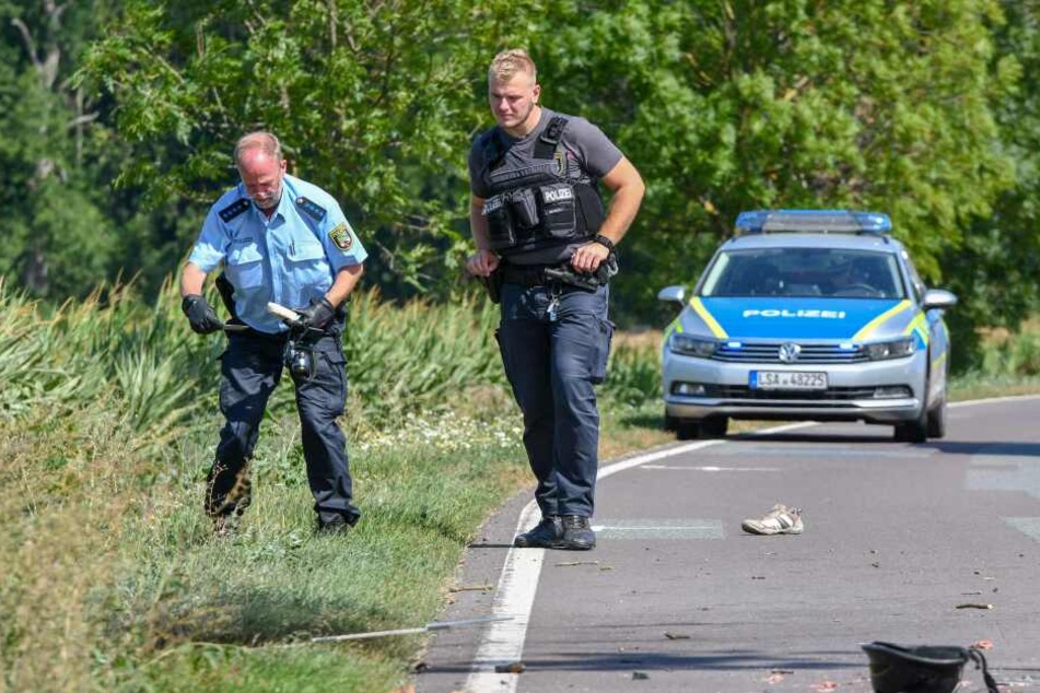 Polizisten sichern Spuren an der Unfallstelle bei Wanzleben.