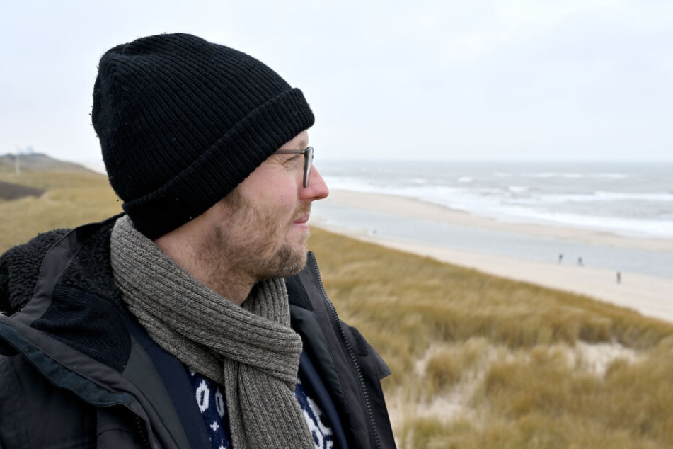 Agrarminister Jan Philipp Albrecht (Bündnis 90/Die Grünen) steht auf der Nordseeinsel Sylt am Strand.