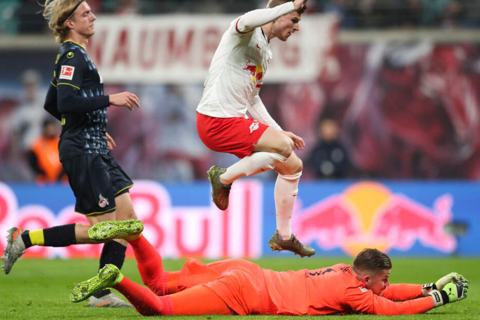 Timo Werner (M) springt nach seinem Torschuss zum 1:0 über Kölns Torwart Timo Horn (liegend), dahinter Kölns Sebastiaan Bornauw.