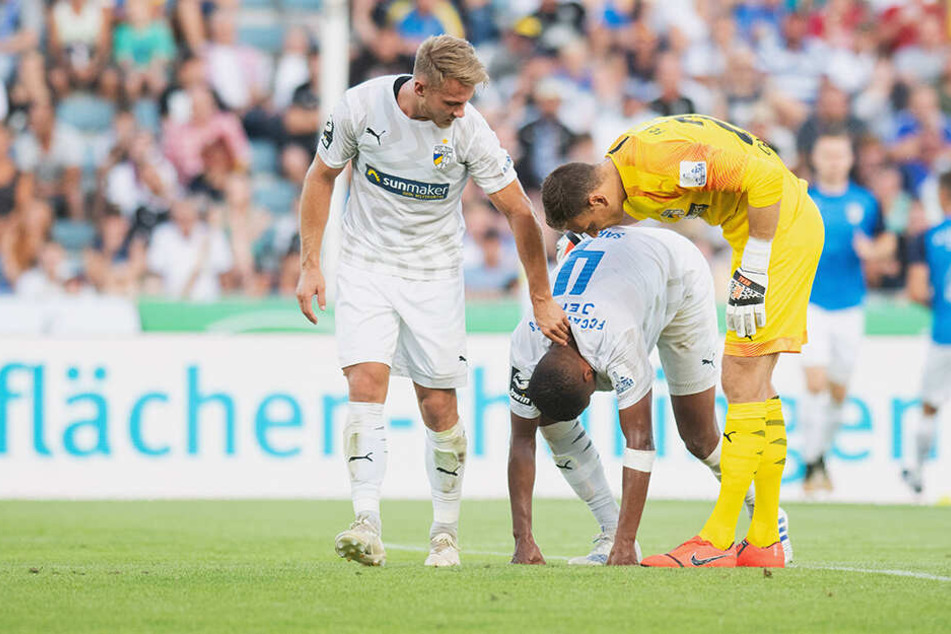 Pierre Fassnacht (links) und Torwart Jo Coppens (Jena, rechts) versuchen Marian Sarr (Jena) nach dessen zweitem Eigentor zum 2:1 für Ingolstadt aufzumuntern. Nun muss der Spieler in die Oberliga rücken.
