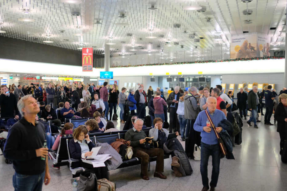 Reisende warten nach dem Zwischenfall auf dem Flughafen.