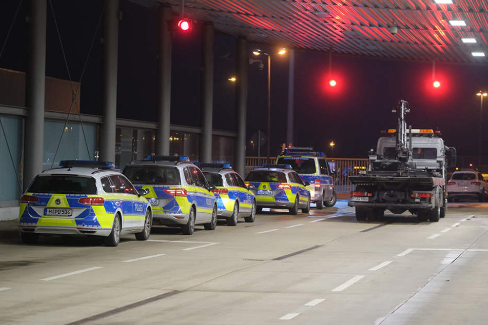 Ein Abschleppwagen steht auf dem Flughafen an der Vorfeldschranke nahe Terminal A neben Polizeiautos.